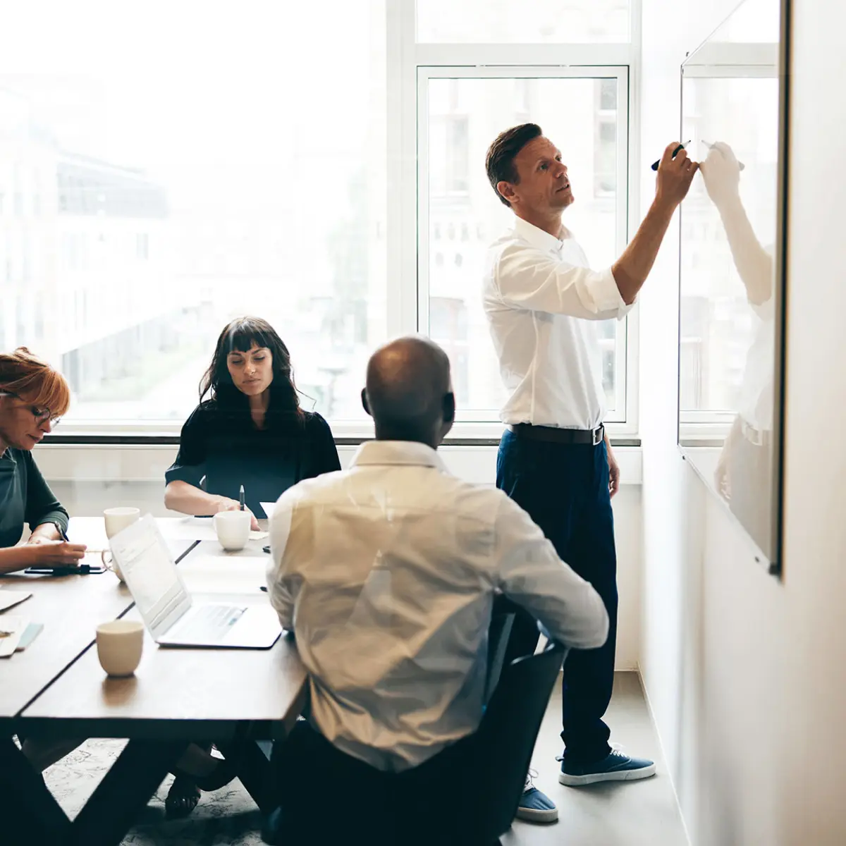image of man drawing on whiteboard in a meeting